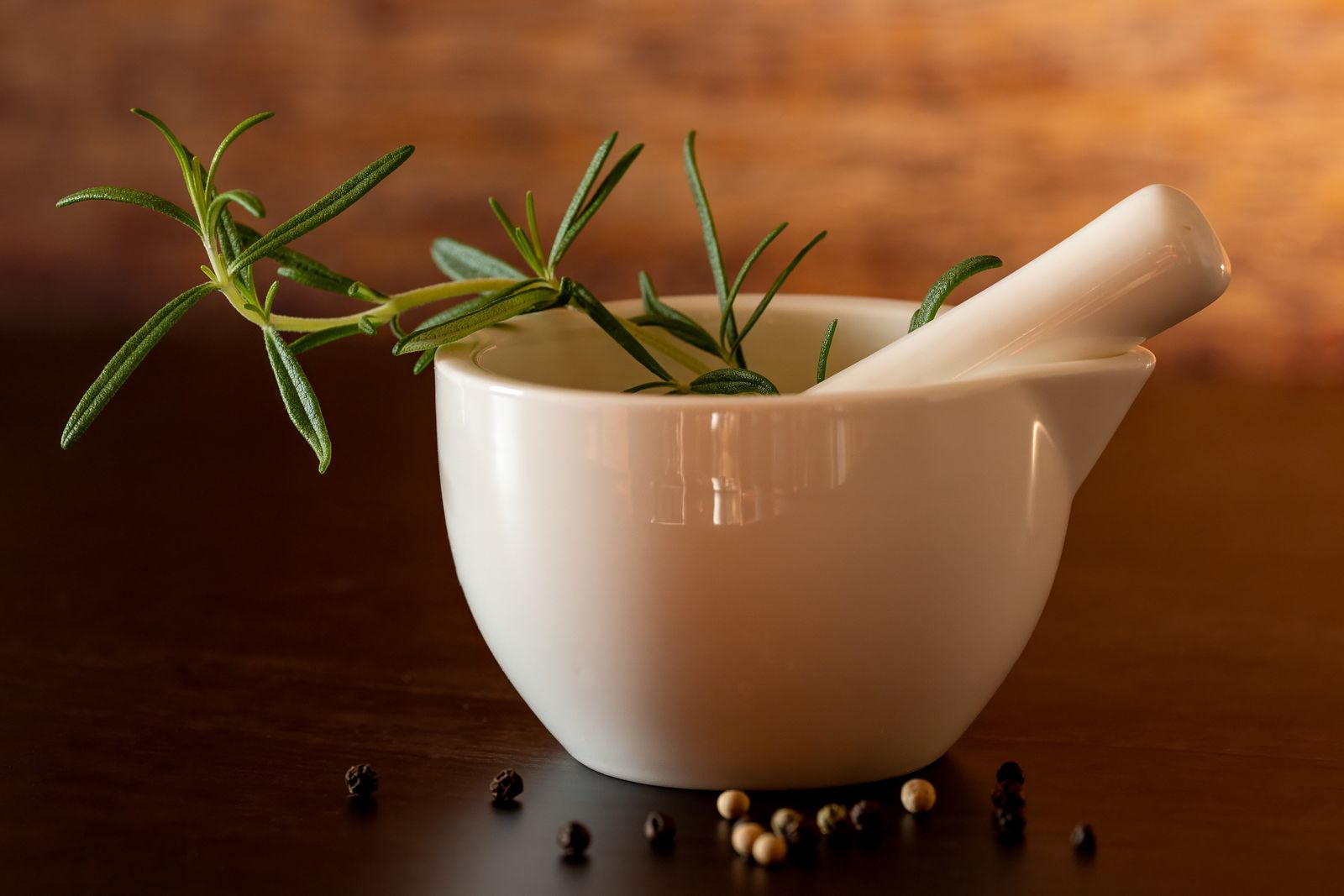 White mortar and pestle with fresh rosemary